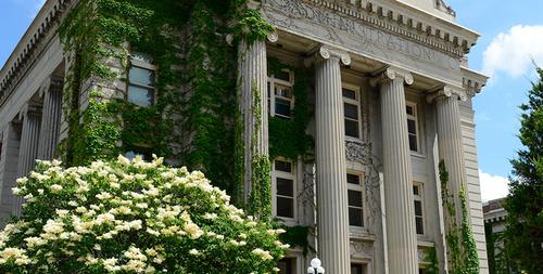 Morrill hall in summer with trees and flowers in bloom