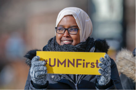 Student holding sign saying UMNFirst