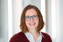 Brianna Menning wearing glasses and a maroon sweater